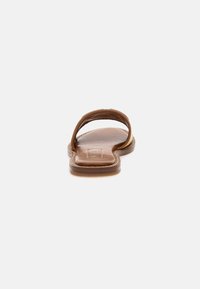 Brown leather slide sandal with a simple two-strap design, flat sole, and stitched detailing along the edges.