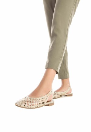 Bailarinas beige, destalonadas, con parte superior trenzada y un bajo tacón en bloque. Cuentan con una correa trasera y textura suave, diseñadas para el uso casual.