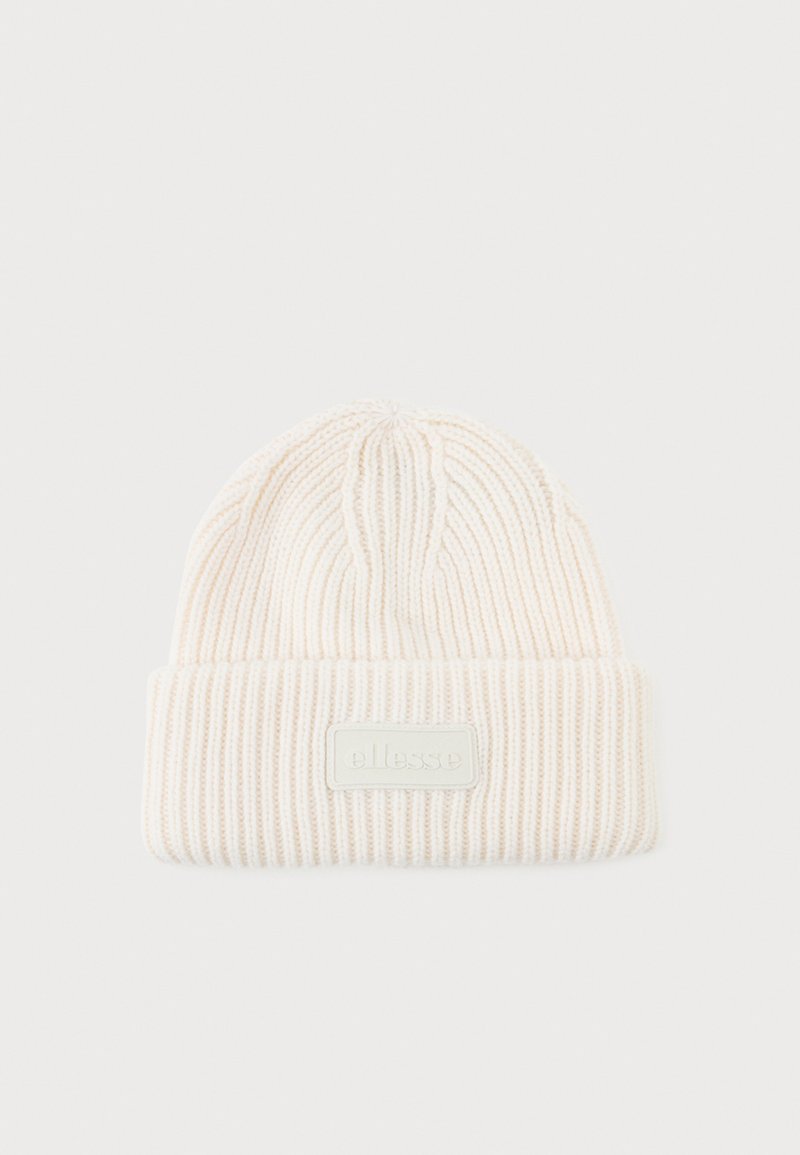 Cream ribbed knit beanie with a folded cuff and a textured finish. Features a rectangular logo patch in a contrasting shade.