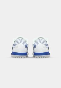 White athletic shoes with blue accents and textured soles. Features curved heel, diagonal stripes, and a padded collar for comfort.
