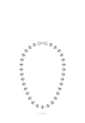 Chaîne de perles en métal de couleur argentée avec un fermoir cylindrique, disposée en boucle sur un fond blanc.