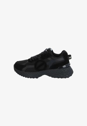 Zapatilla deportiva negra con suela texturizada, parte superior de malla y ante, diseño con cordones y lengüeta en el talón con marca blanca.