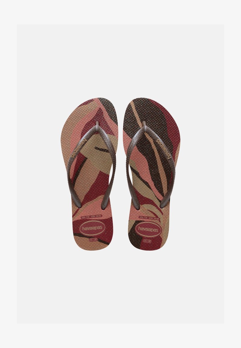 Barna és rózsaszín mintás Havaianas papucsok páros, texturált talppal és barna Y-alakú pántokkal, fehér háttérrel.