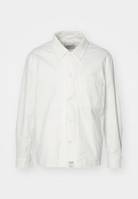 Cămașă albă cu guler clasic, din bumbac, cu mâneci lungi și un singur buzunar pe piept. Textură netedă, design simplu.