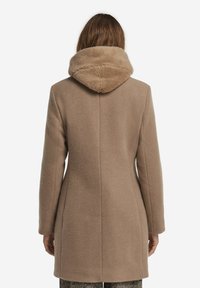 Beige ullkappa med en plyschfoderad huva, en strömlinjeformad design, långa ärmar och midja-längd, med en slät textur.