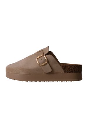 Beżowe zamszowe klapki typu slip-on z szerokim paskiem i złotą klamrą, z korkową wkładką i gumową podeszwą dla wygody i wsparcia.