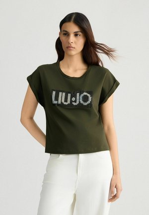 Olive green cropped t-shirt with rolled sleeves featuring a sequin-embellished "LIU·JO" logo on a black rectangular background.
