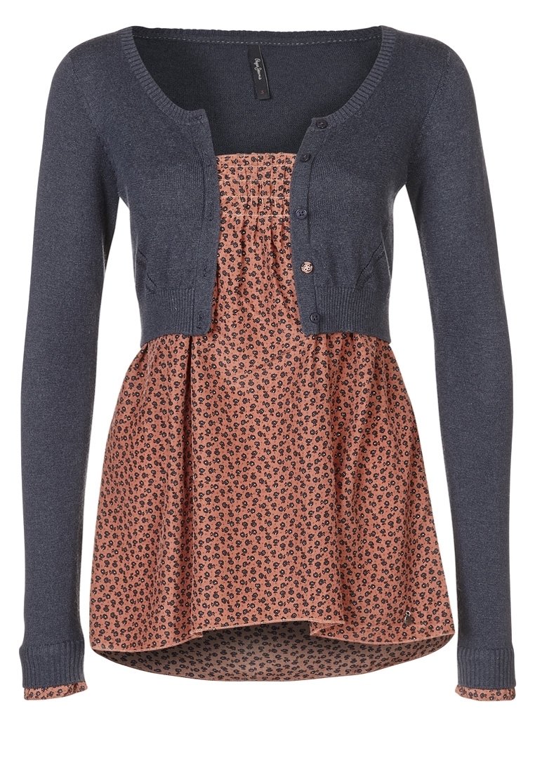 Námořnický pletený cardigan přes květinovou blůzu s potiskem v odstínech broskve a černé. Má knoflíky a rozšířený spodní lem.