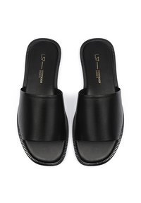 Sandales à glisser en cuir noir avec une large sangle, semelle plate, bord texturé et logo en relief doré sur la semelle intérieure.