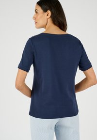 Camiseta navy de manga corta con escote redondeado y detalle texturizado en los hombros, hecha de una suave mezcla de algodón.