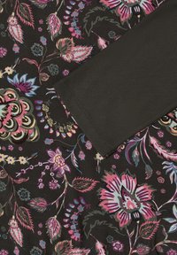 Ärmel aus dunklem Stoff, der über schwarzen Stoff mit pinken, lila, blauen und gelben Blumen- und Blattmustern gelegt ist.