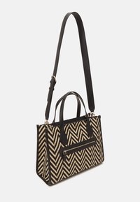 Sort og beige vævet håndtaske med et chevron-mønster, der har dobbelte håndtag, en aftagelig skulderrem og en frontlomme med lynlås.