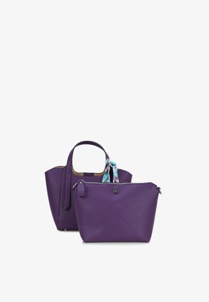 Zwei violette Ledertaschen, eine größere Tote mit Griffen und einem gemusterten Schal, der daran befestigt ist, und eine kleinere Tasche mit Reißverschluss vorne.