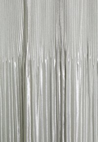 Tecido metálico pregueado em tom prateado, apresentando linhas verticais com uma textura suave e brilhante. Pregas espaçadas uniformemente criam um design fluido.