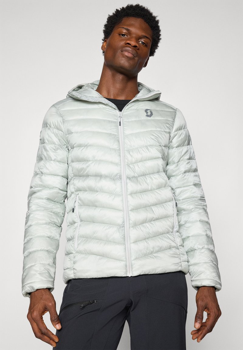 Jasnozielona kurtka puchowa z zamkiem błyskawicznym, kapturem i dwoma bocznymi kieszeniami. Pikowana konstrukcja z gładką, błyszczącą teksturą. Logo na piersi.