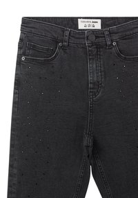 Czarne dżinsy o dopasowanym kroju, z kieszeniami z przodu, ozdobione rozrzuconymi metalowymi ćwiekami dla dodatkowego efektu.