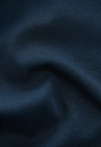Dark blue, smooth cotton fabric with a subtle ribbed texture, featuring soft folds and undulating lines creating a gentle wave pattern.