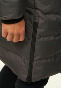 Daunenjacke in Dunkelgrau mit strukturiertem, gestepptem Design. Verfügt über eine seitliche Reißverschlusstasche und einen elastischen Ärmelbund für einen sicheren Sitz.