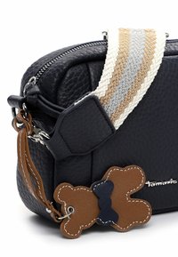 Czarna skórzana torebka na ramię o fakturowanej powierzchni, z wzorzystym plecionym paskiem w kolorach beżowym, szarym i białym oraz brązowo-granatowym dekoracyjnym akcentem.