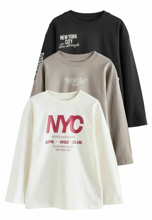 Drie lange mouwen T-shirts: zwart, beige en wit. Elk heeft distinctieve graphics gerelateerd aan New York en Tokyo. Zachte katoenen textuur.