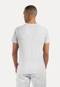 Grå kortærmet skjorte med rund hals, der har en glat tekstur og raglanærmer. Bagsiden viser et simpelt design og rene linjer.