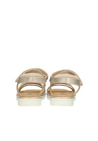 Sandali metallici beige con cinturini alla caviglia regolabili, soletta imbottita e suola in gomma bianca. Design aperto sul retro e dettagli con ritagli.