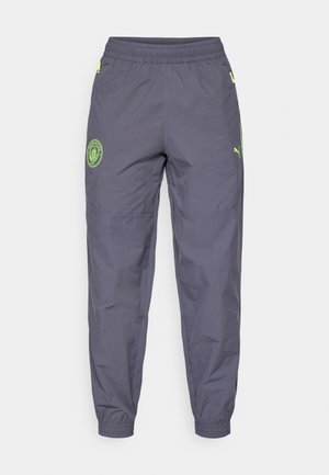 Grå sportsbukser med en afslappet pasform, elastisk talje og grøn logo detalje. Lavet af letvægts, tekstureret materiale med elastiske ærmer.
