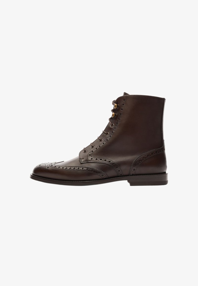 Stivale alla caviglia in pelle marrone con dettagli brogue, punta rotonda e design con lacci e occhielli metallici. Texture liscia e suola robusta.