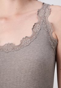 Harmaa ribbiteksuri tank top, jossa on herkkä pitsireunus avonaisessa kauluksessa ja olkaimissa, joka on pehmeä tekstuuri ja tiukka malli.