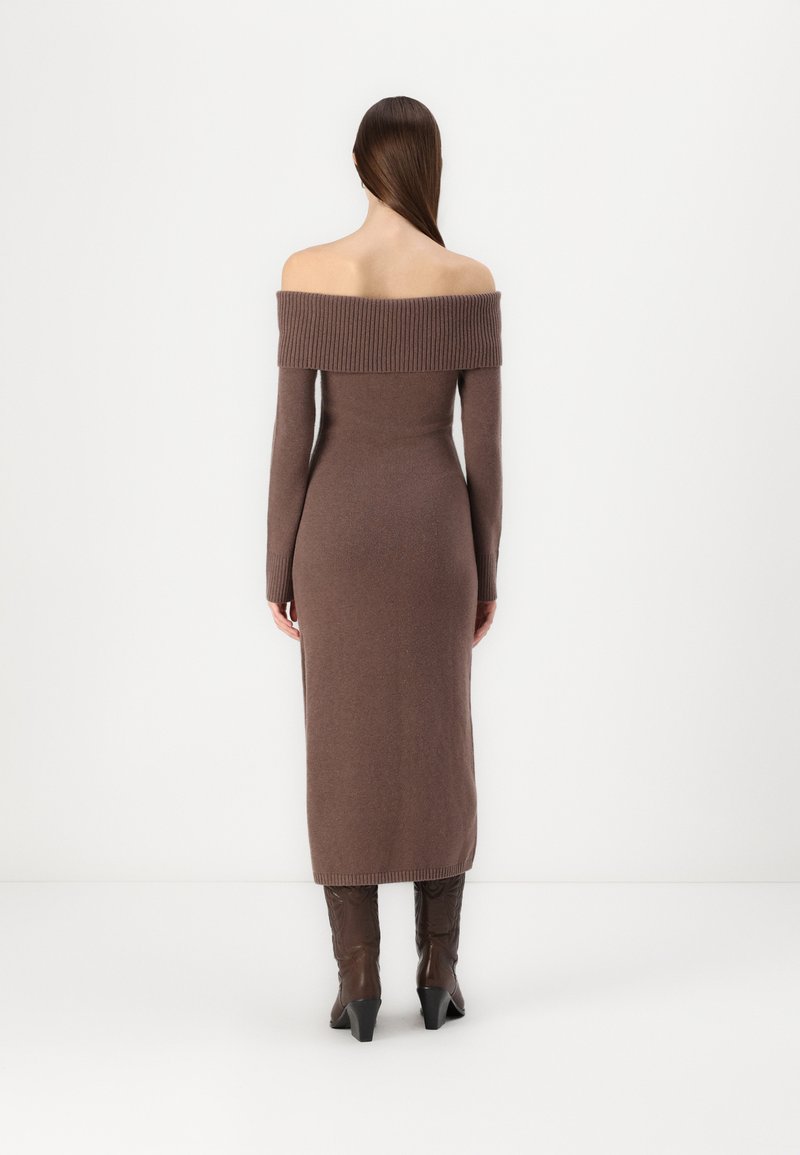 Strickkleid in strukturierter brauner Optik mit schulterfreiem Design, langen Ärmeln und taillierter Silhouette bis zur Mitte der Wade. Mit geripptem Ausschnitt akzentuiert.