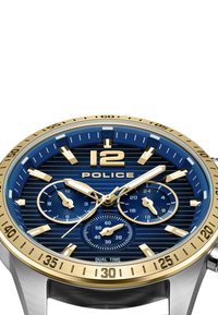 Modrý a zlatý hodinky s textúrovaným ciferníkom, ktorý má tri subciferníky, luminescenčné hodinové značky a púzdro z nehrdzavejúcej ocele.
