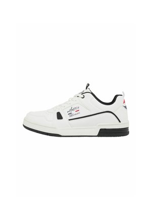 Witte lage sneaker met zwarte rand, zwarte zool, veters en merktekst "atletico" en "Carlo Colucci" aan de zijkant.