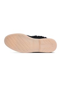 Svart sneaker med mjukt ovandel, texturerad gummisula och en ljusbeige yttersula med mönstrat grepp för bättre friktion.