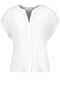Blouse blanche à manches courtes en tissu texturé, col rond, fermeture par boutons sur le devant et coupe décontractée.