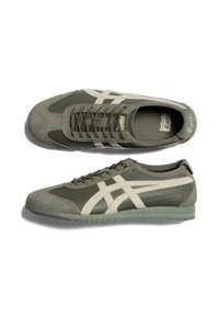 Green athletic sneakers with suede and mesh materials, featuring beige accents, lace closure, and textured sole.
