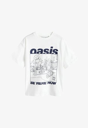 Biele tričko s námorníckym modrým textom „oasis“ a „be here now“, ktoré rámuje čiarový nákres pouličnej scény s stromami, budovami, ľuďmi a skútrom.