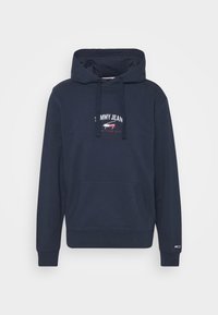 Marinblå hoodie i mjukt tyg, med en främre ficka, ribbade ärmslut och en logotyp med röda och vita detaljer.