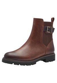 Des bottes chelsea en cuir marron présentent un corps texturé et un détail de boucle noire sur une sangle contrastante. Semelle en caoutchouc épaisse avec un motif de traction.