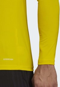 Langdurige sportieve shirt met lange mouwen in helder geel, met een gestructureerde stof en AEROREADY branding nabij de zoom, met een aansluitende pasvorm.