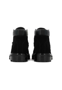 Juodi suede auliniai batai su lygiu juodu odiniu apykakle, masyviu juodu guma padu ir minimaliais detaliais ant nugaros.