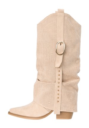 Botte mi-mollet en daim beige avec design perforé, sangle décorative avec boucle dorée et clous, bout pointu et talon bas empilé.