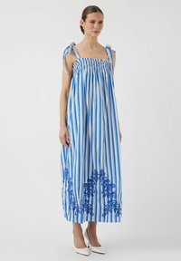 Blå og hvidstribet maxi kjole med smocket barm, skuldert ties og blå blomsterbroderi ved kanten. Glat stof, afslappet pasform.