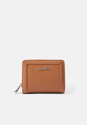 Brown leather wallet with textured surface, zip closure, and silver Lacoste logo on the front. Rectangular shape with stitched accents.