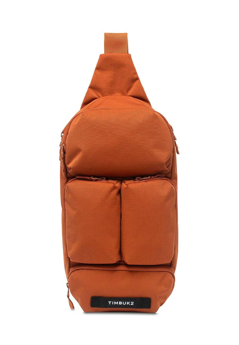 Borsa a tracolla arancione in tessuto con manico superiore, dotata di tre tasche frontali con zip, design elegante e etichetta nera TIMBUK2.
