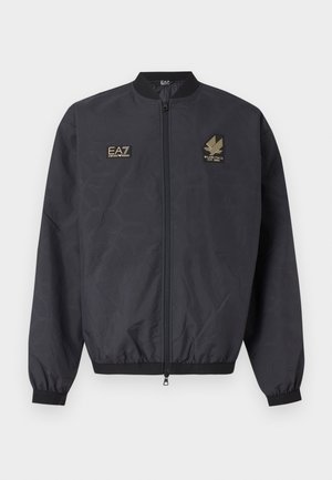 Črno bomber jakno z zadrgo, z rebrastim ovratnikom, manšetami in spodnjim robom, na prsih z dvema zlatima vezenima logotipoma EA7 Emporio Armani.