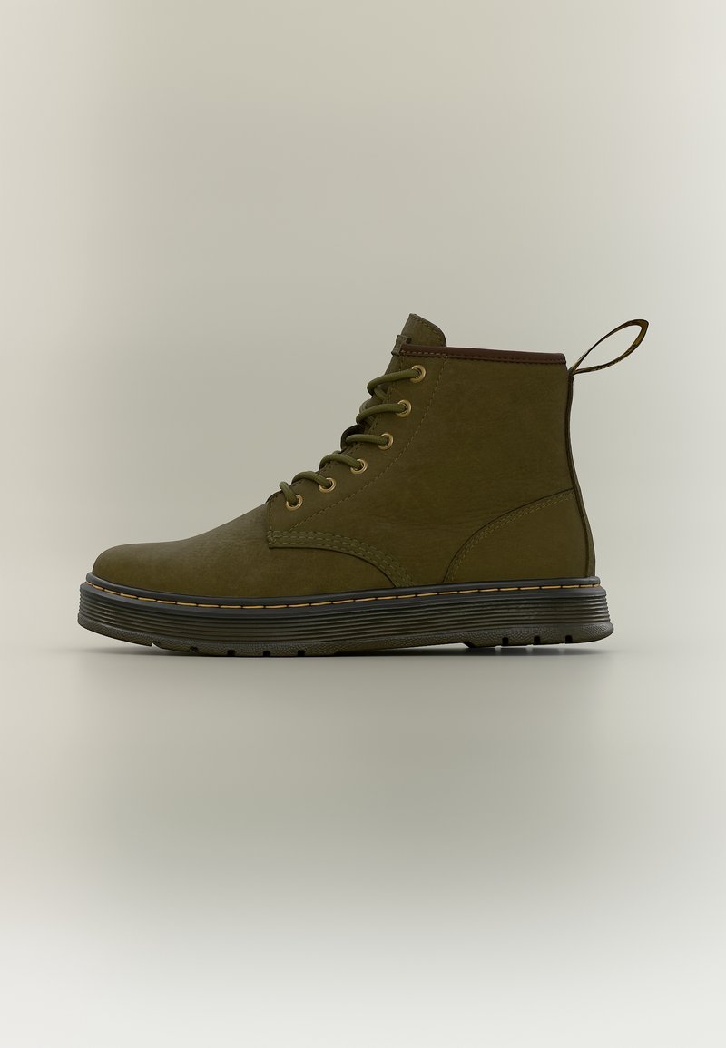 Bottine en cuir vert olive à lacets, semelle noire et surpiqûres jaunes, avec une languette au talon.