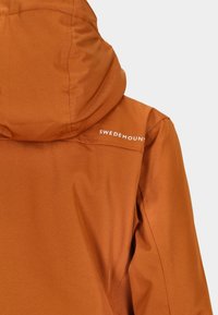 Braune Kapuzenjacke aus glattem, wasserabweisendem Material. Verfügt über ein Logo auf der Schulter und ein einfaches, sauberes Design.
