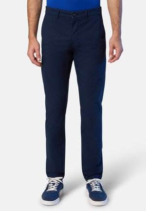 Pantaloni in cotone blu navy con taglio dritto, dotati di chiusura a bottone e zip, tasche frontali, abbinati a scarpe sportive blu navy.