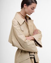 Beige trench coat with a wide collar and oversized sleeves, featuring a belt with a rectangular buckle and a smooth texture.
