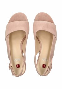 Měkké broskvové nubukové sandály s otevřenou špičkou, křížovými pásky a kulatým knoflíkem detailně umístěným u kotníku. Hladký vnitřek s minimálním brandingem.